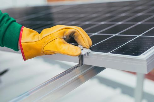 mano poniendo tornillo en placa solar