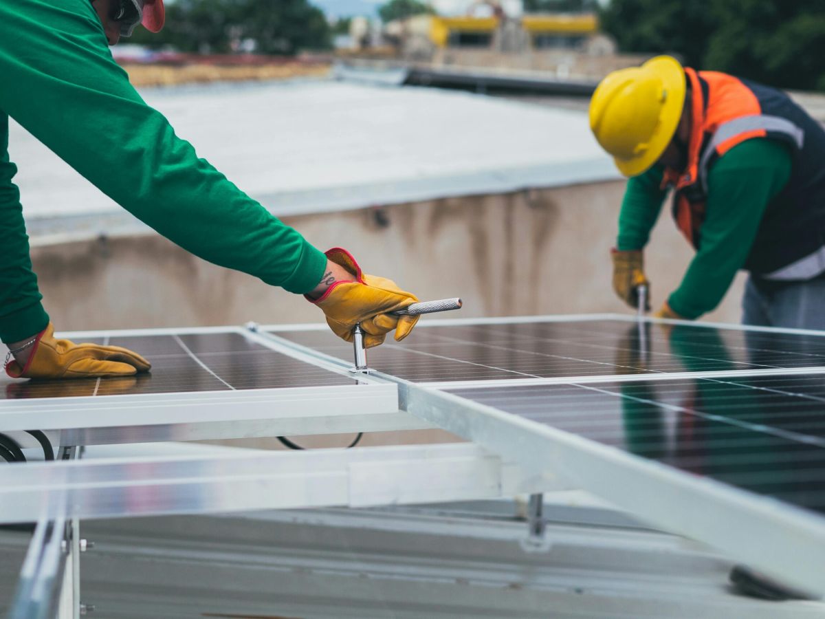 profesionales uniendo placas solares con herramienta
